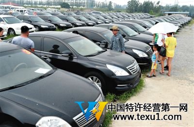 昨日，市民在山東棗莊一家拍賣公司場地上查看待拍賣公車。當日，棗莊市103輛公車公開拍賣。新華社記者